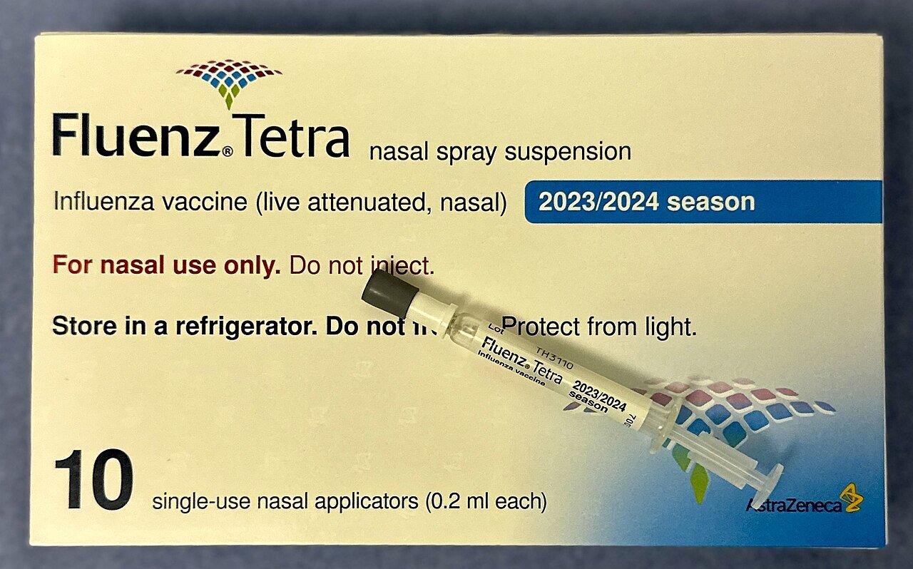 A box of Fluenz Tetra nasal spray flu vaccine with a single-use nasal applicator lying on top