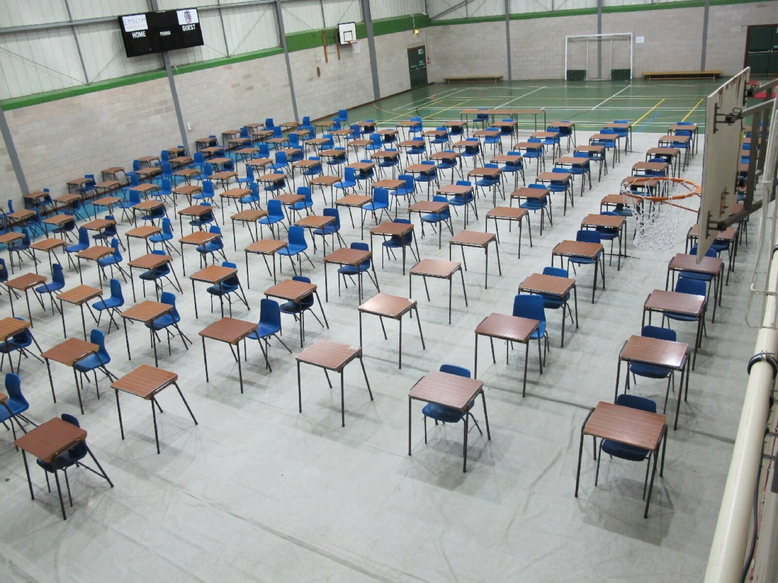 Rows of exam desks laid out in a school sports hall